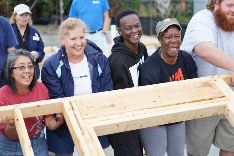 Family and volunteers raising a wall