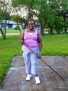Amedia Jones wearing work gloves and holding a rake.