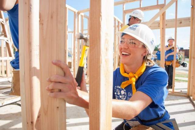 VOLUNTEER AS AN INDIVIDUAL. Women helping to frame a house.